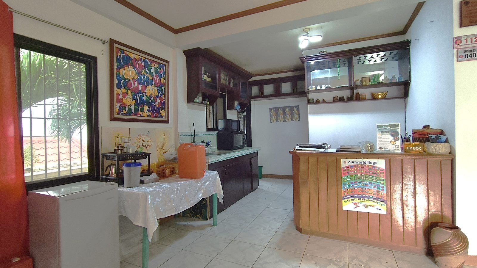 Reception desk and the guest kitchen, with the wall of world flags